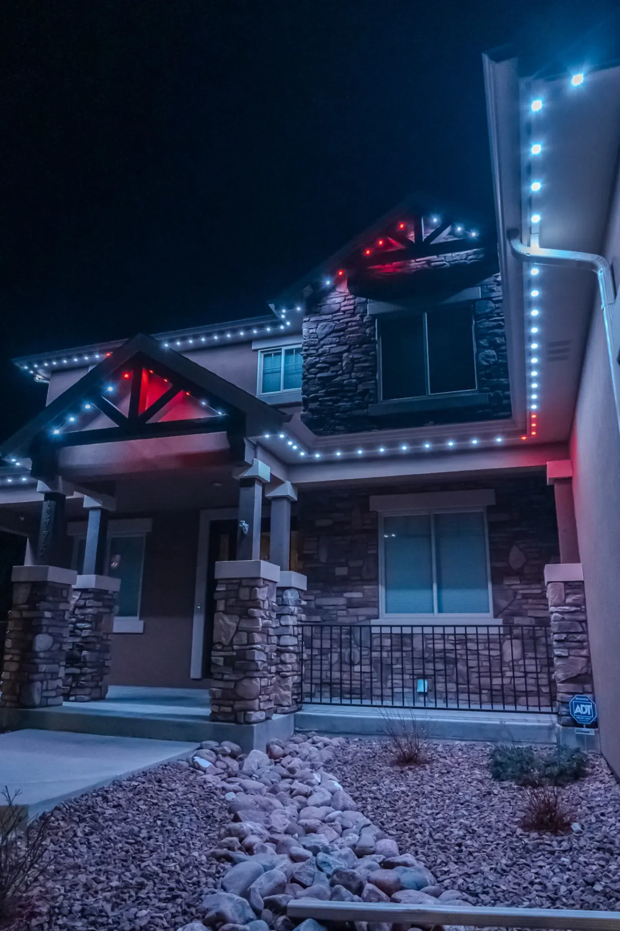 Cool white and red accent lighting on a craftsman home