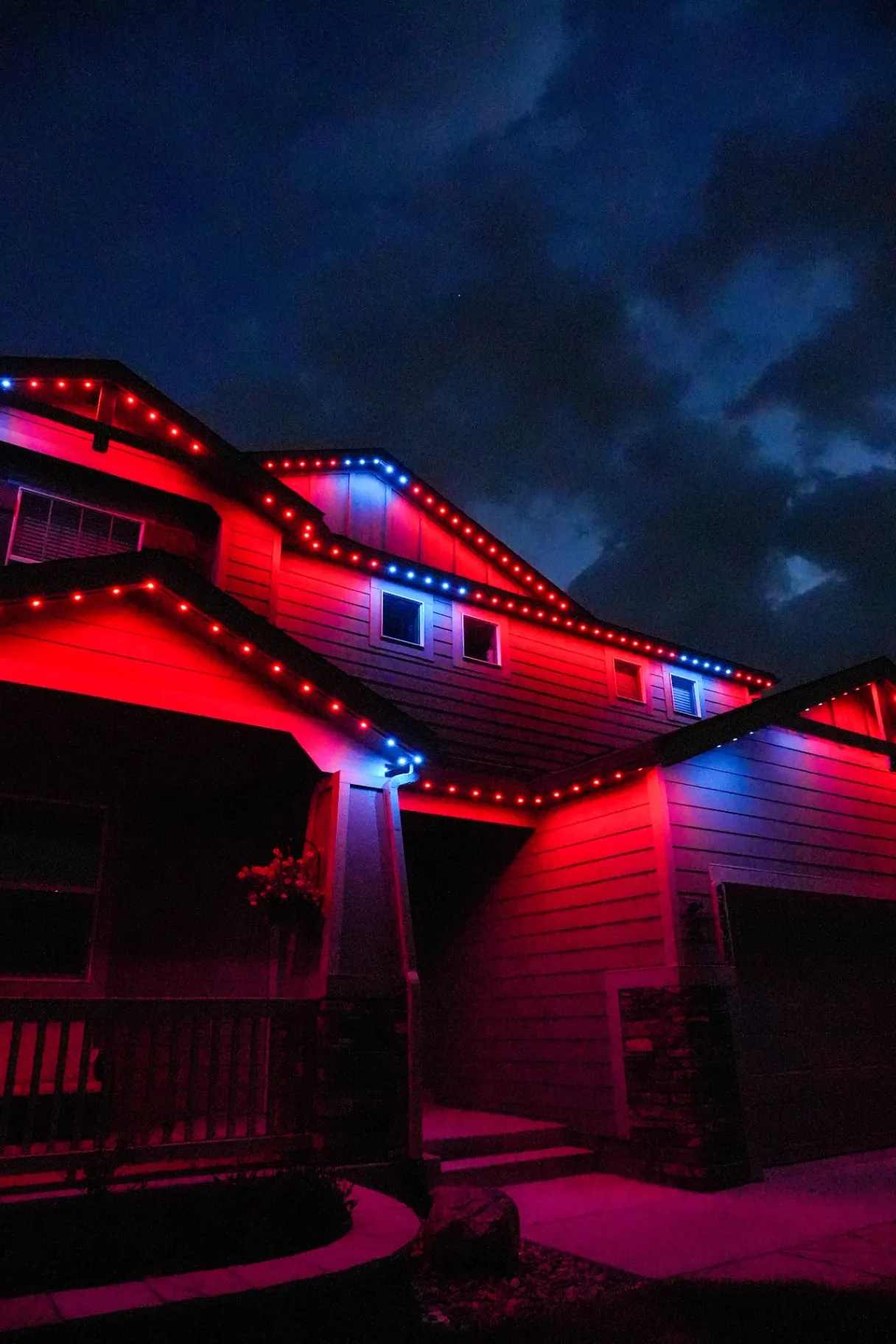 Patriotic red and blue permanent lighting on a two-story home