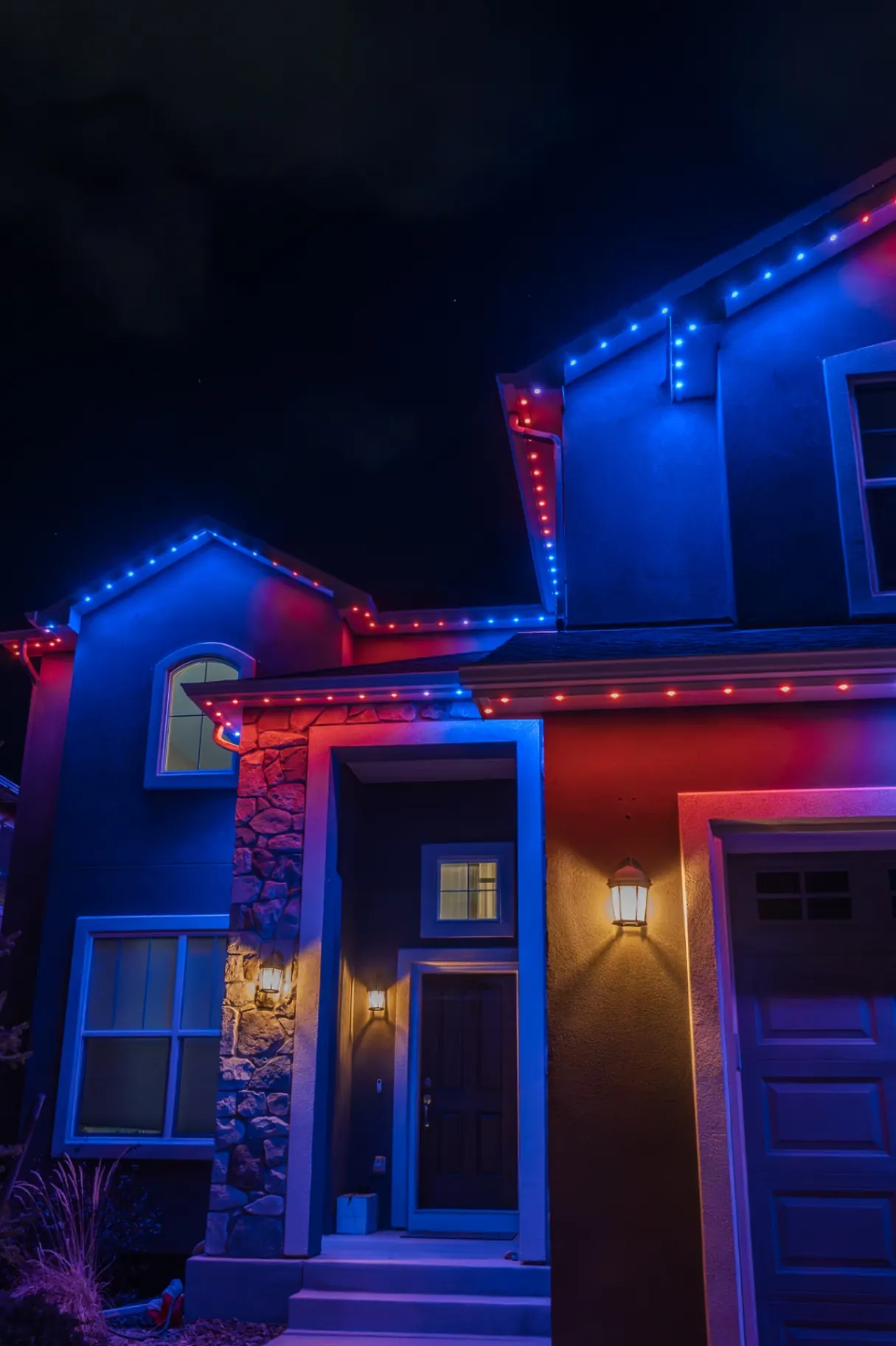 Red and blue lighting illuminating a home entry and garage