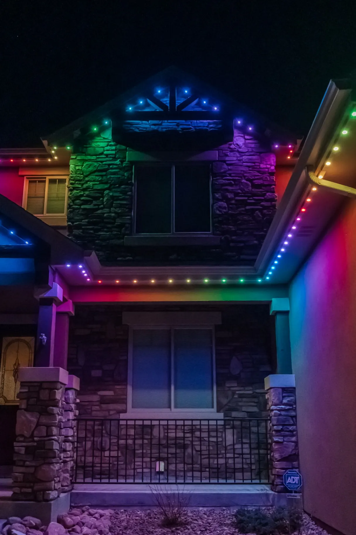 Rainbow lighting on a stone-front home entry