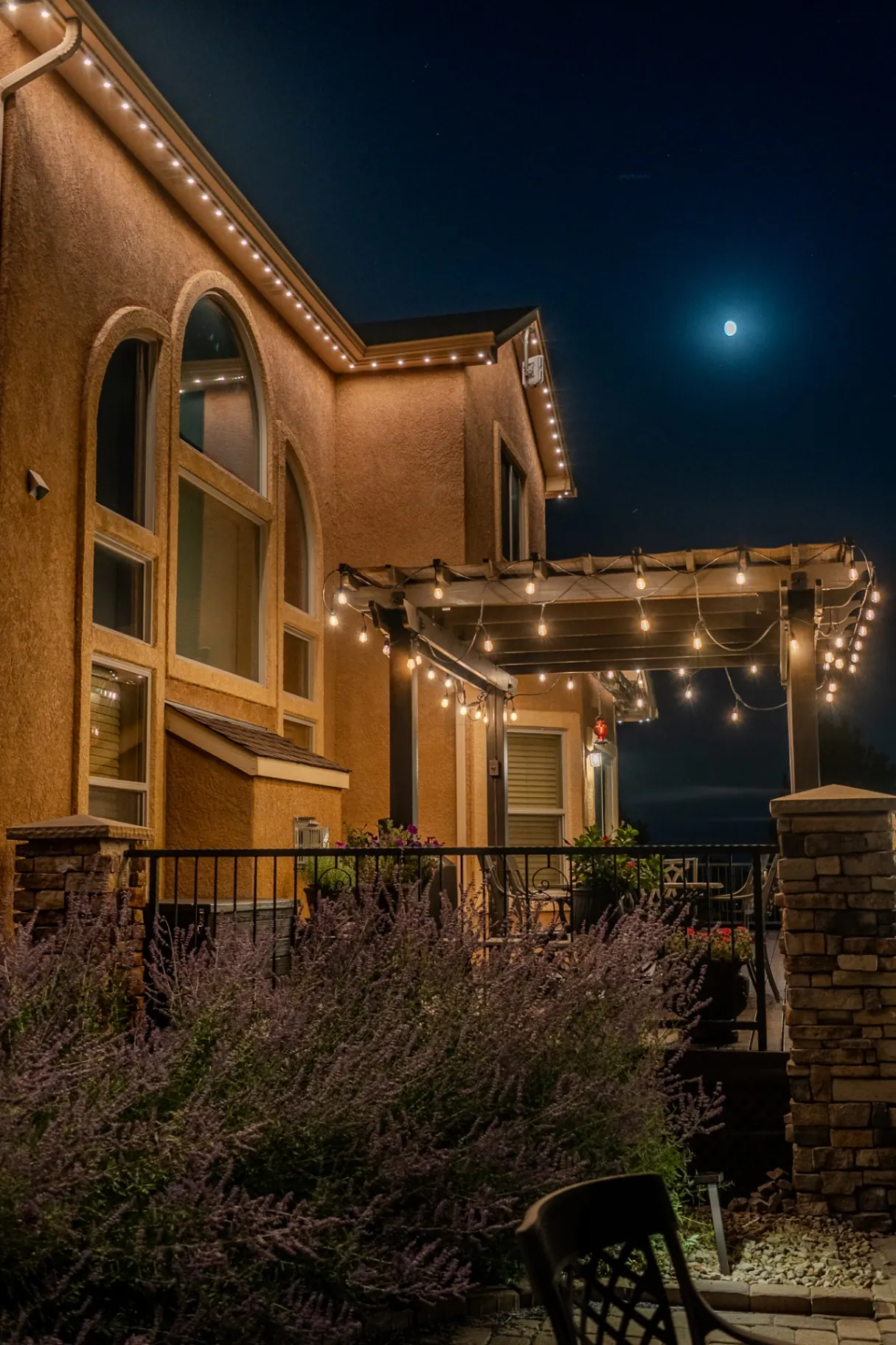 Warm white lighting on a backyard patio and pergola
